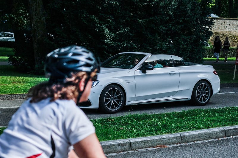 A car and a bicycle crossing each other on a road