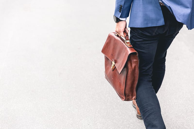 Man walking with brown leather suitcase