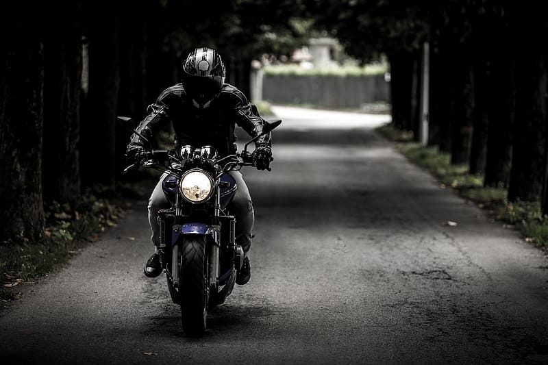 Someone riding a motorbike under a bridge