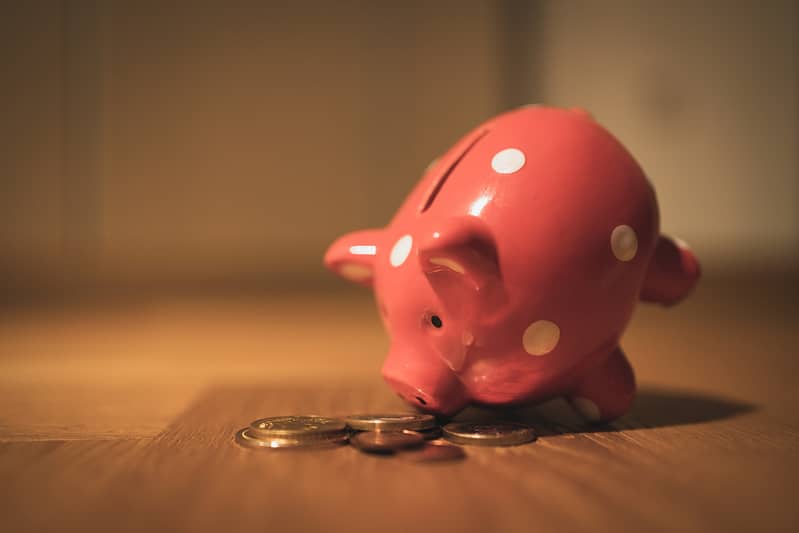 A piggy bank with coins on a table