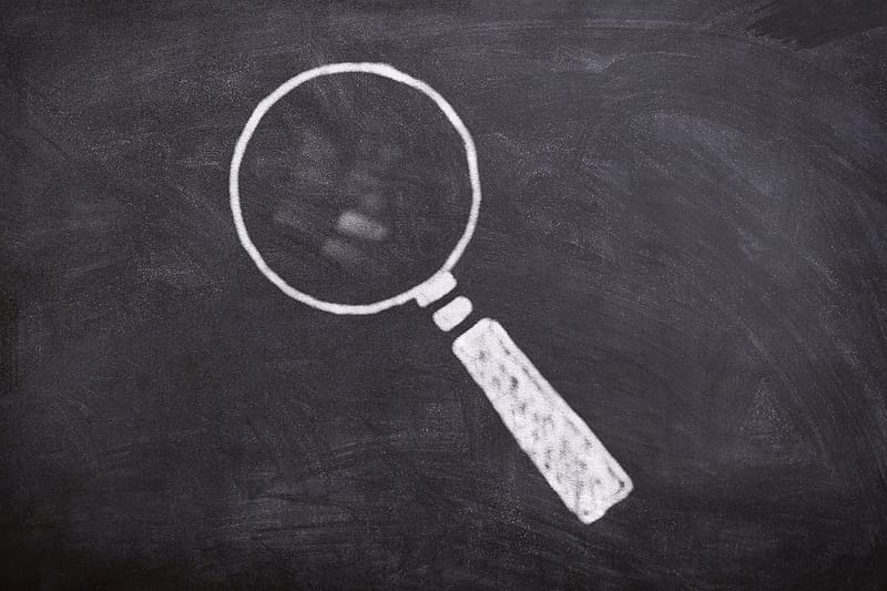 a magnifying glass drawn on a chalkboard