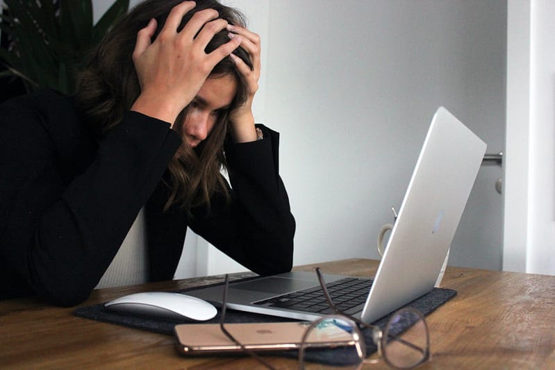 Someone looking stressed on their laptop