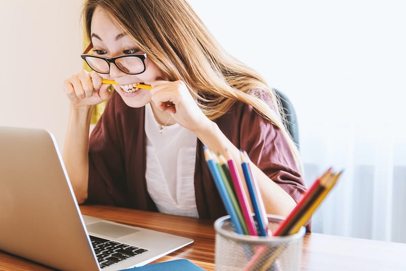 Someone biting a pencil out of stress