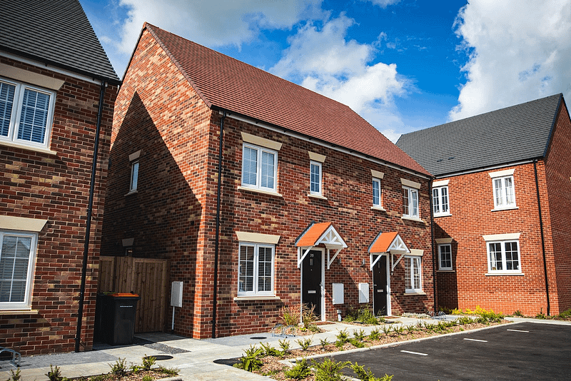 a newly built red brick house on a cul de sac