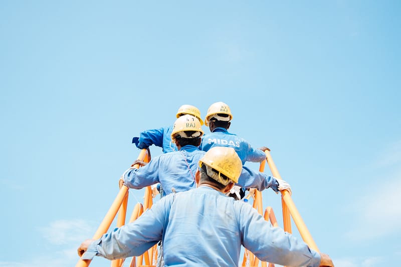 Four men in hardhats climbing stairs