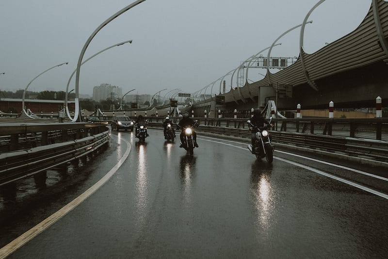 A group of motorbikes in front of a car on the motorway