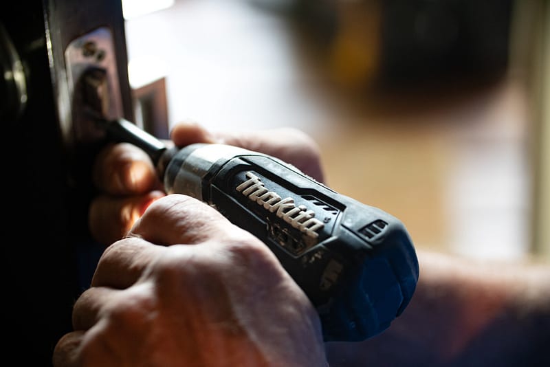 An electric drill fixing a door lock