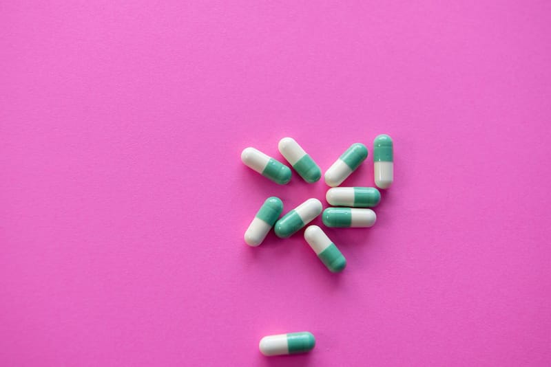 Pills against a pink background