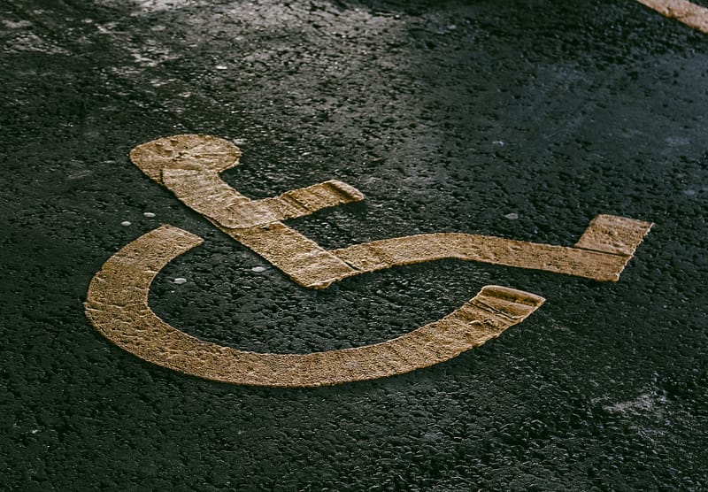 A yellow wheelchair sign on a parking spot