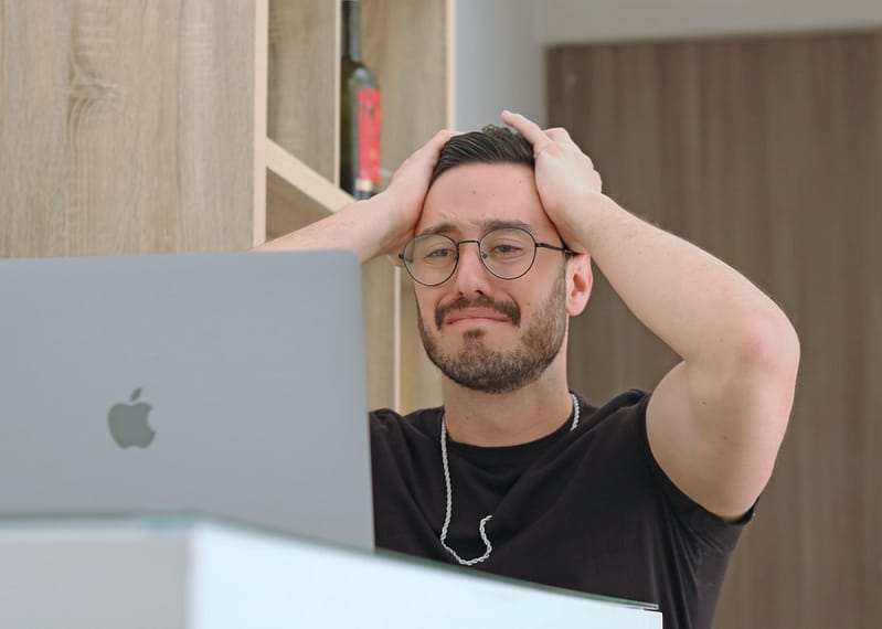 someone looking regretful at their laptop