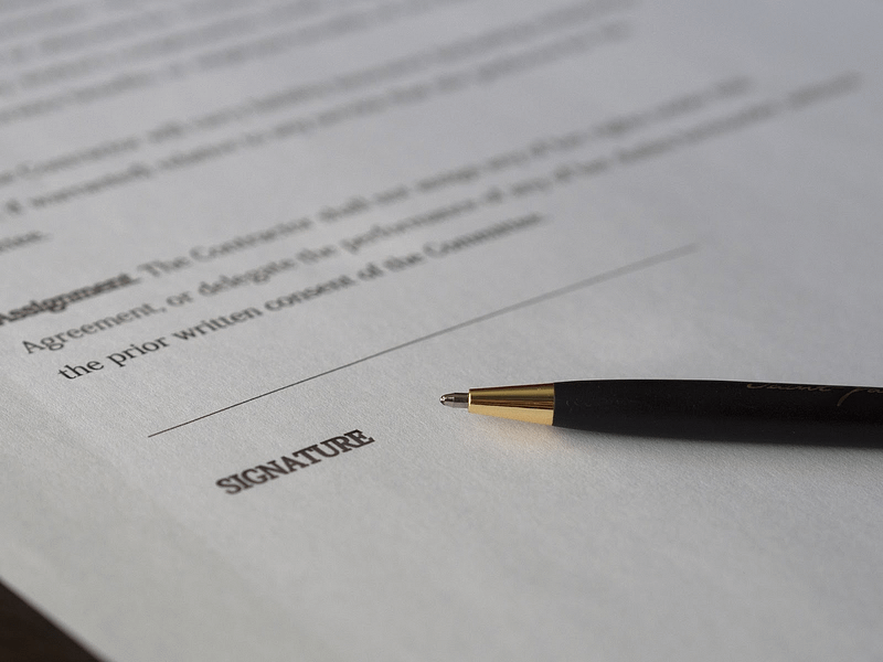 A close up image of a pen resting against paperwork