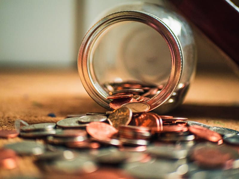 A collection of coins fallen out of a jar