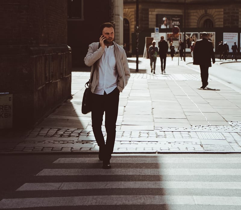 someone crossing the road on the phone