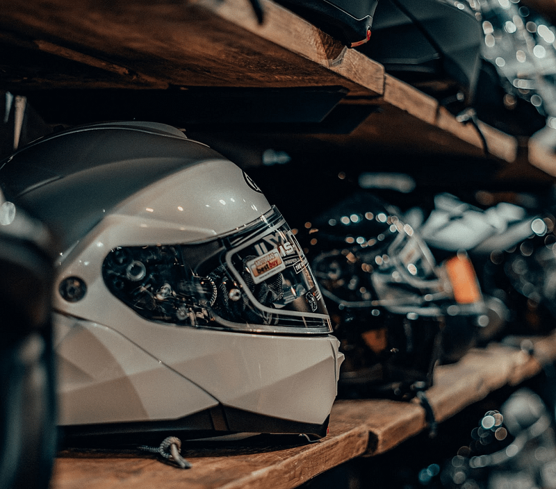 A shelf full of motorbike helmets